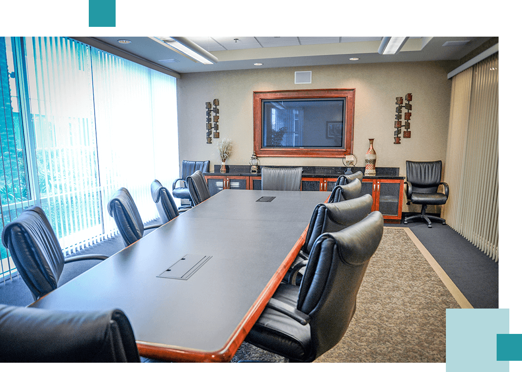 A conference room with a large table and chairs.