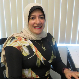 A woman in a hijab sitting at a desk.